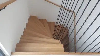 Moderní dřevěné schodiště s kovovými lanovými zábradlím.