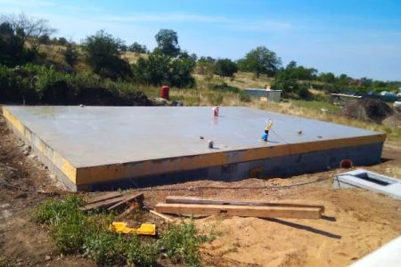 Čerstvě nalitá betonová základní deska na staveništi.