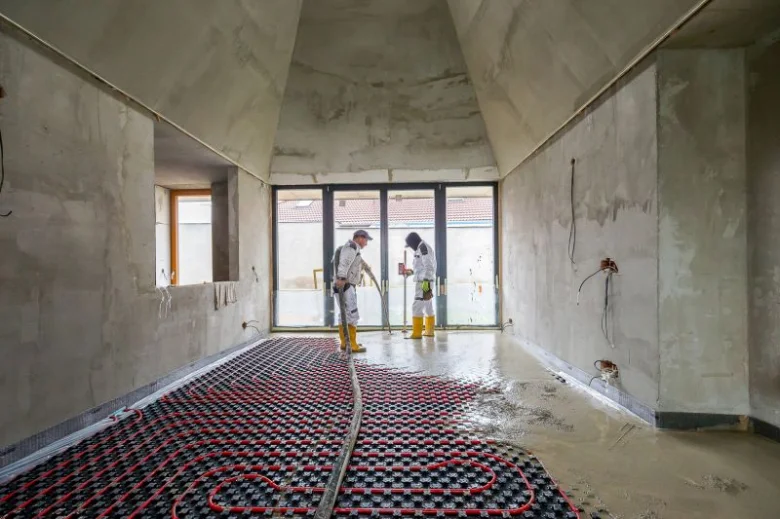 Instalace podlahového topení s potrubím na izolační mřížce.