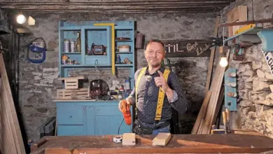 Dřevěný řemeslník s nástroji pro čepování trámů v dílně.