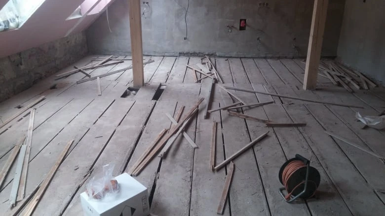 Příprava podlahy na vyrovnání s roztroušenými dřevěnými prkny.