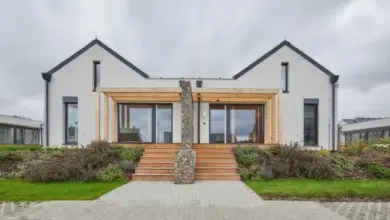 Moderní dřevostavba s difuzně otevřenou stěnou na pozadí zelené zahrady.