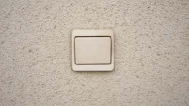 Bežný vypínač světla na texturované stěně.