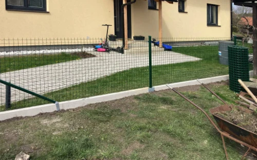 Nízký drátěný plot jako ochrana proti psům v zahradě.