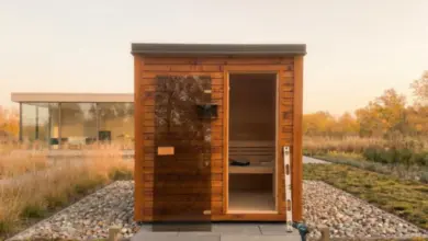 Dřevěná sauna s otevřenými dveřmi během stavby na zahradě.