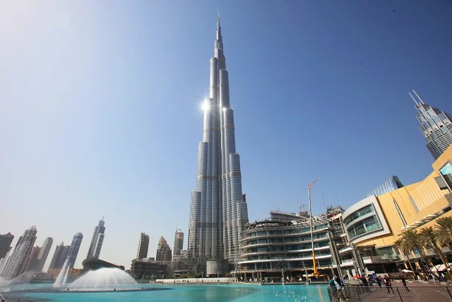 Burj Khalifa ve Dubaji na modré obloze s fontánou.