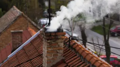 Kamín na střechě s kouřem, typický pro plynové kotle.