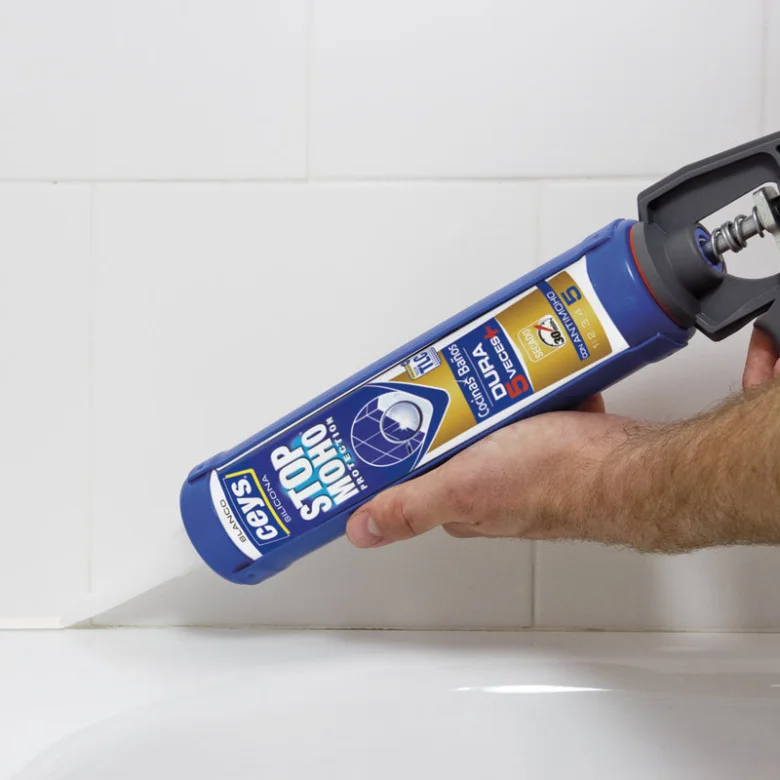 Ruční aplikace sanitárního silikonu v koupelně na dlažbu.