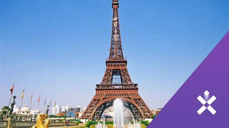Velká kopie věže Eiffel s fontánami pod modrou oblohou.