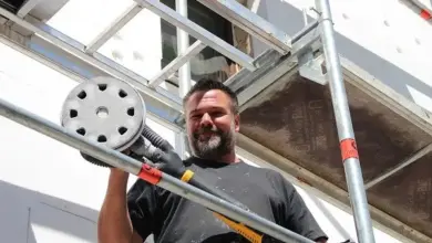 Man with sander on scaffolding
