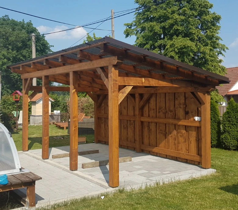Dřevěná pergola s otevřenými stranami na zahradním pozemku.