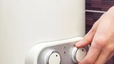 Ruka nastavuje teplotu na elektrokotle v koupelně.