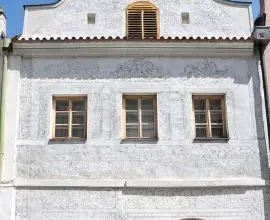 Historická budova se škrábnutými ornamenty na fasádě.