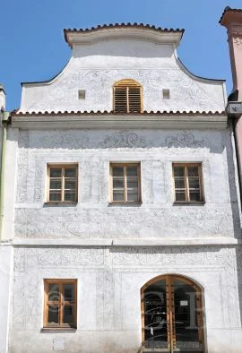 Historická budova se škrábnutými ornamenty na fasádě.