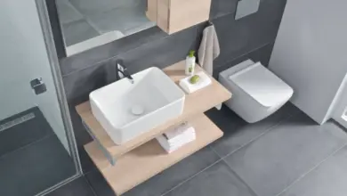 Moderní koupelna s umyvadlem a WC v tmavě šedých dlaždicích.