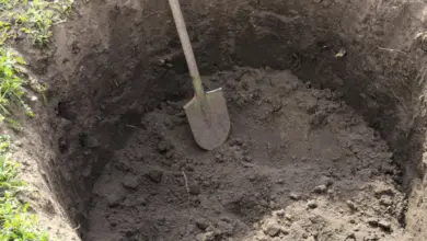 Kopáč v vykopaném jámě pro vsakovací jímku.