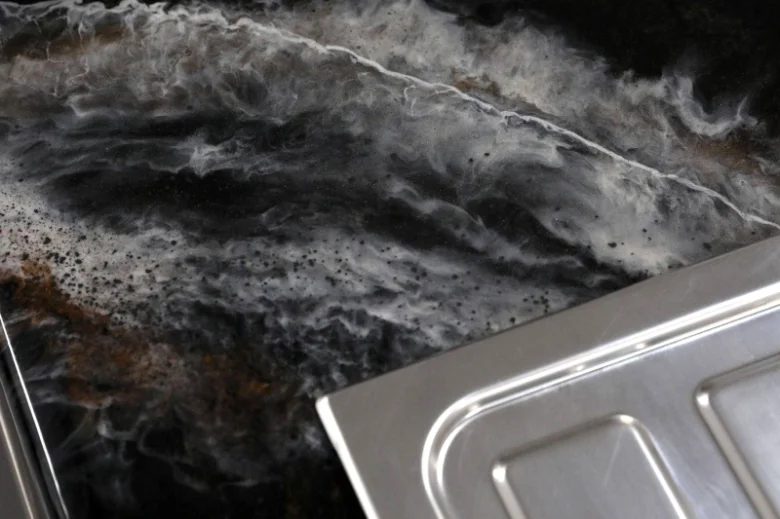 Poškozená kuchyňská pracovní deska s škrábancemi před renovací.
