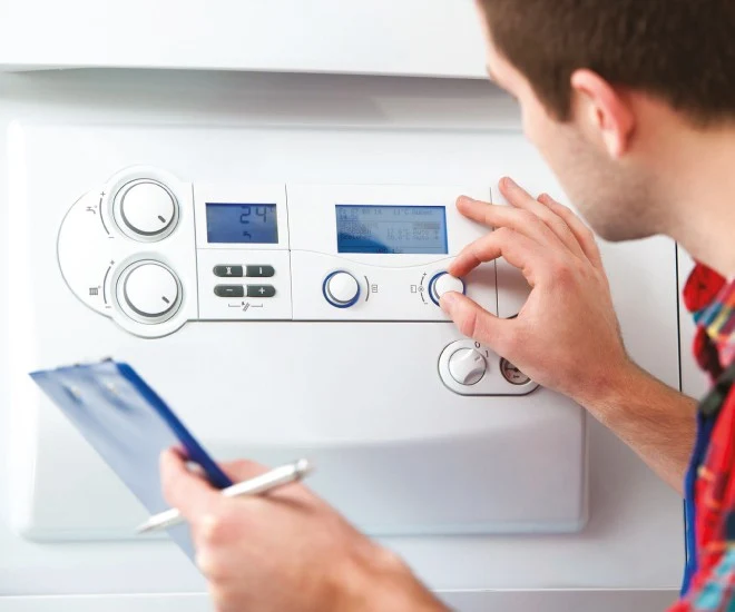 Man adjusting boiler controls
