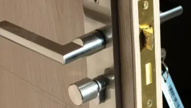 Moderní zámek u dveří s klikou, jazykem a kladkou.