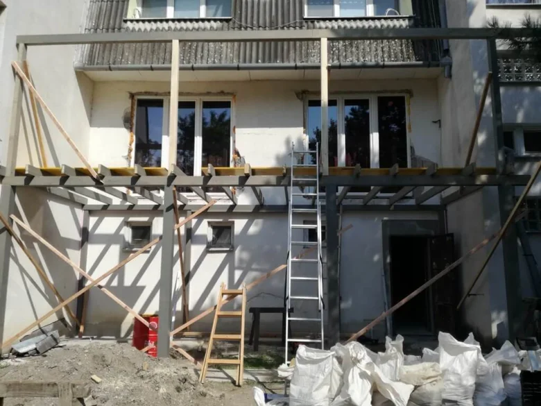 Stavba domu s instalací oken na fasádě.