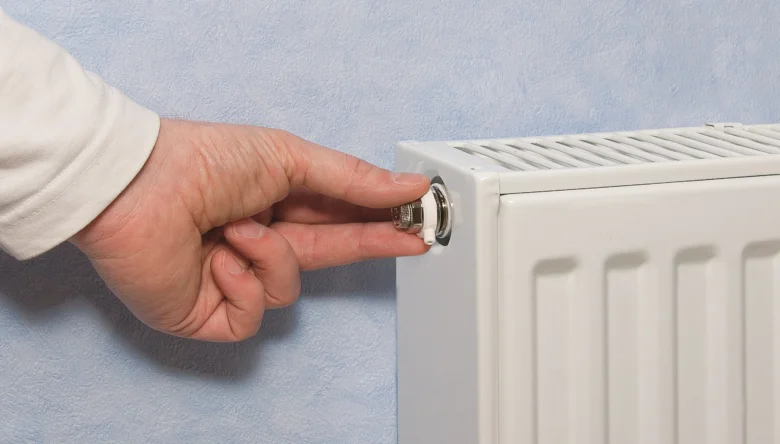 Ruka otáčí odvzdušňovací ventilátor na radiátoru.