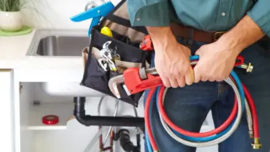 Montér s nářadím u kuchyňské baterie