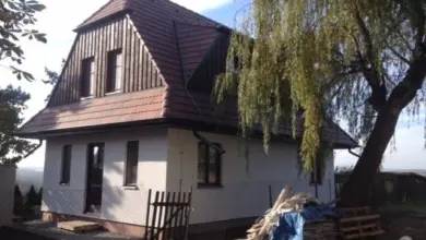 Rodinný dům v rekonstrukci s materiály a paletami uvnitř dvora.