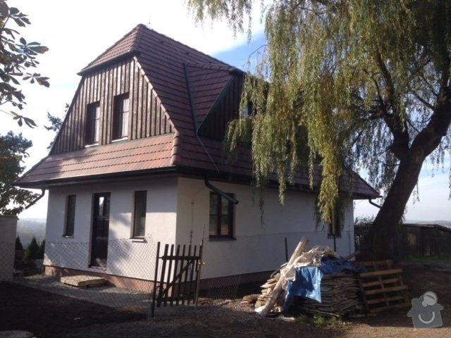 Rodinný dům v rekonstrukci s materiály a paletami uvnitř dvora.