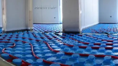 Moduly s červenými hadicemi pro podlahové topení v patře.