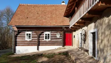 Tradiční hrázděný dům s dřevěným rámem a červenou střechou.