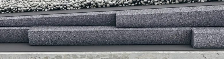 Detail ukončení ploché střechy s kamennou fasádou bez atiky.