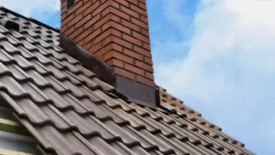 Kamínová komína z cihel na střeše s taškami.