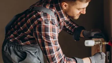 Muž čistí topný systém kompresorem z prachu.