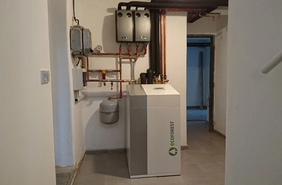 Instalace tepelného čerpadla s měděnými potrubími v technické místnosti.