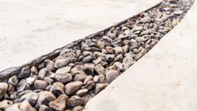 Přesné uspořádání kamenů kačírků v betonu na zahradě.
