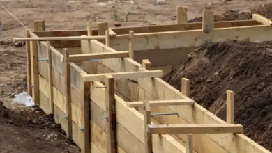 Stavba dřevěného bednění pro opěrnou zeď z betonu.