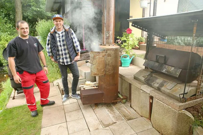 Dva muži u domluveného grilu z bojleru v zahradě