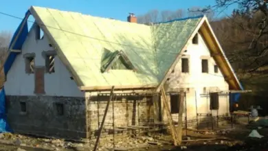 Starý dům s novou izolací na střeše během rekonstrukce.