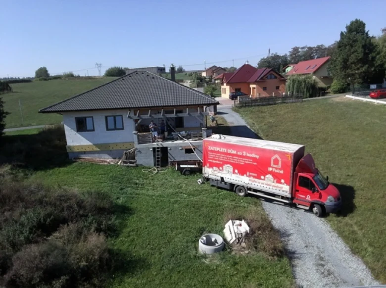 Nákladní vůz s foukanou izolací u domu v rekonstrukci