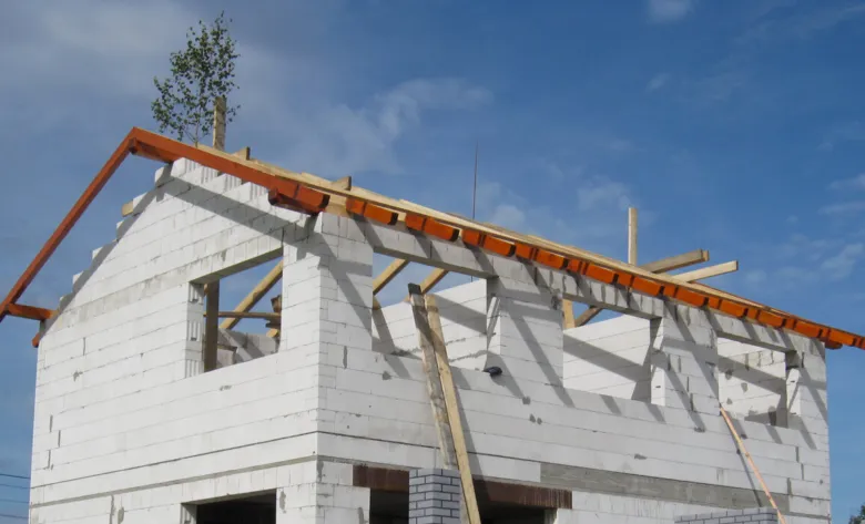 Stavba dřevěného střešního krovu na domě z bloků.