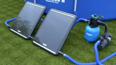 Solární panel pro ohřev bazénu s filtrem na trávě.