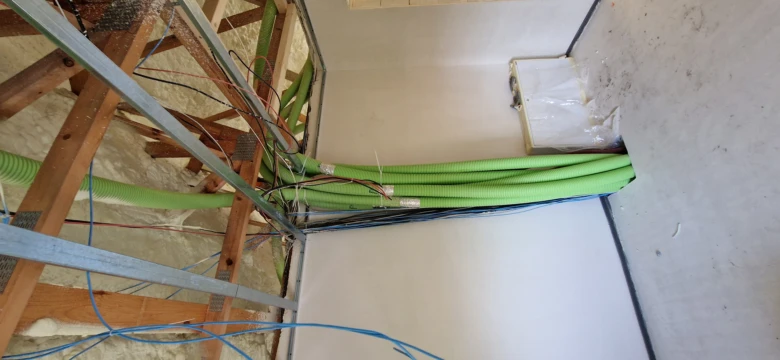 Zelené potrubí rekuperace v krovu stropu při instalaci.