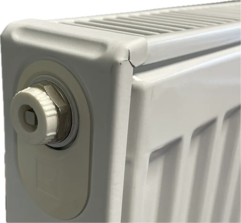 Bílý radiátor s plastovým odvzdušňovacím ventilom pro vypouštění vzduchu.