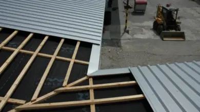 Konstrukce pultové střechy s dřevěnými trámy a kovovou krytinou.