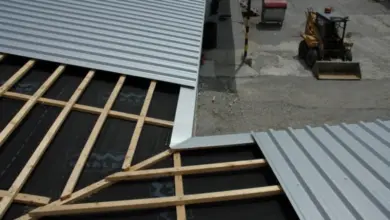Stavba pultové střechy s dřevěným rámem a kovovou krytinou.
