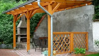 Dřevěná pergola s krytou střechou pro ochranu před větrem.