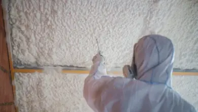 Pracovník aplikuje expandující izolační pěnu na vnitřní stěnu.