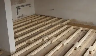 Dřevěné trámy pro podlahu v budově během stavebních prací.