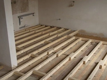 Dřevěné trámy pro podlahu v budově během stavebních prací.