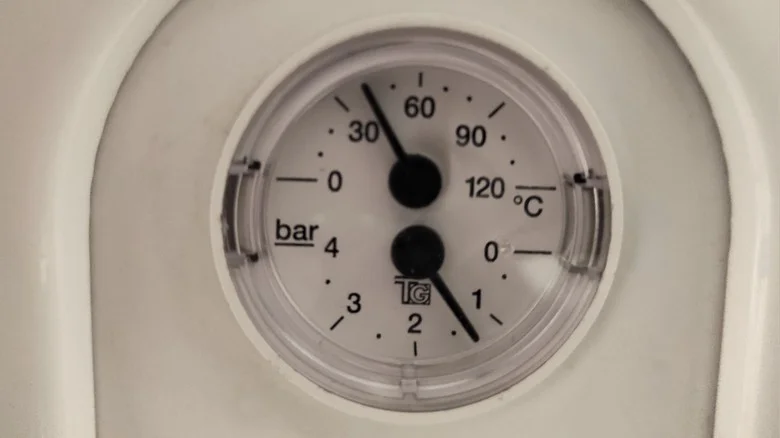 Termostat s teploměrem pro radiátory na bílém zařízení.